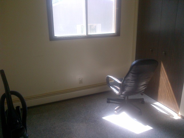 The spare bedroom with a lonely office chair that's broken.